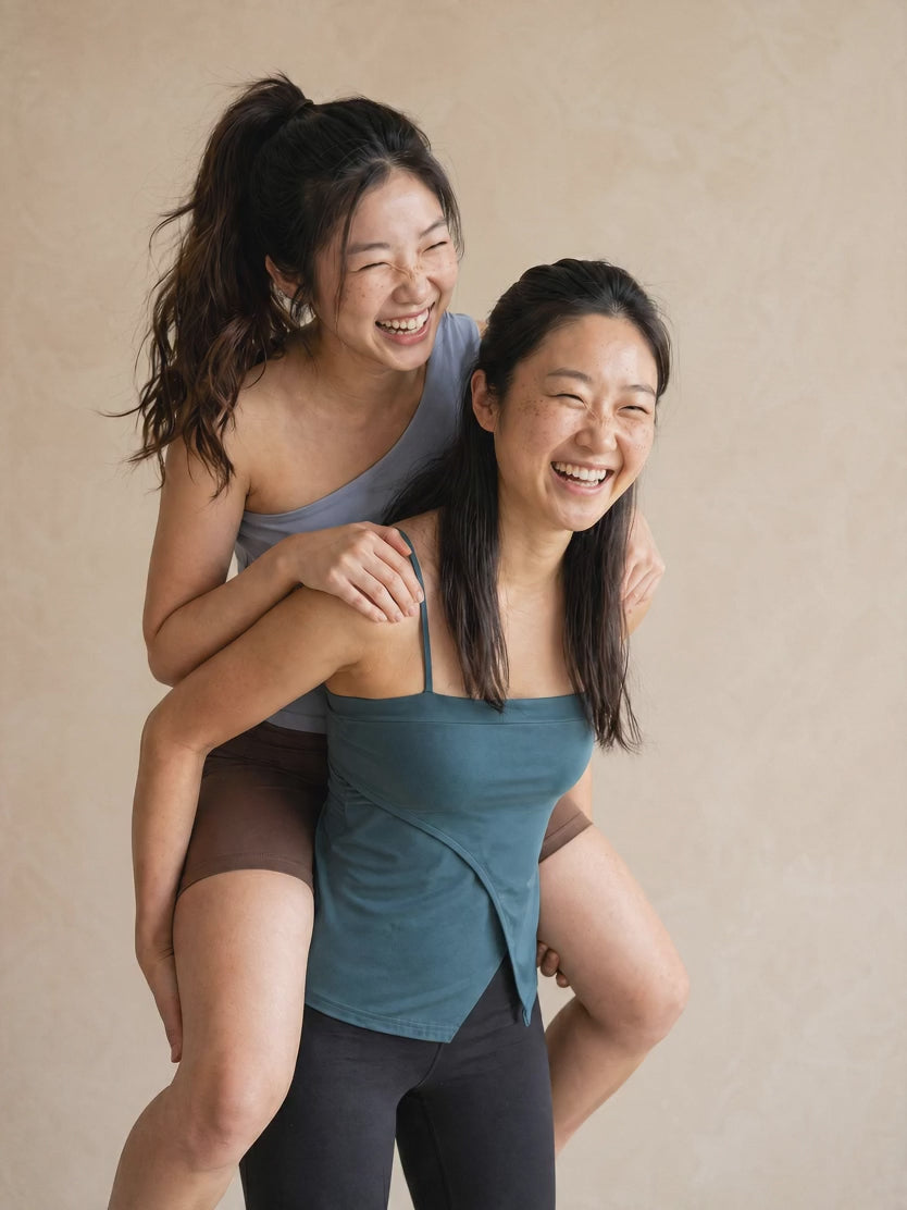 One woman giving another woman a piggy back ride, both in genuine happiness, smiling
